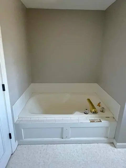 Before image of a bathroom needing renovation with old tiles and fixtures.