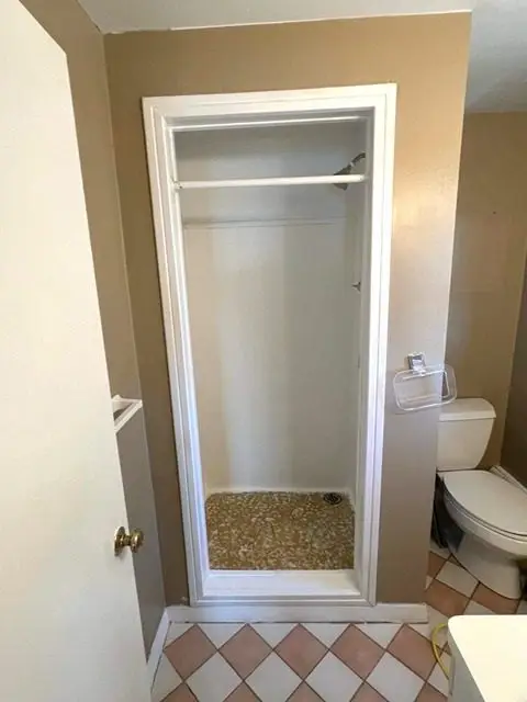Before bathroom renovation showing cramped space with old decor and fixtures.