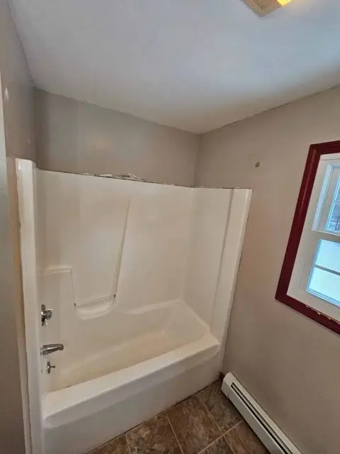 Before image of a bathroom in need of renovation, highlighting outdated fixtures and design.