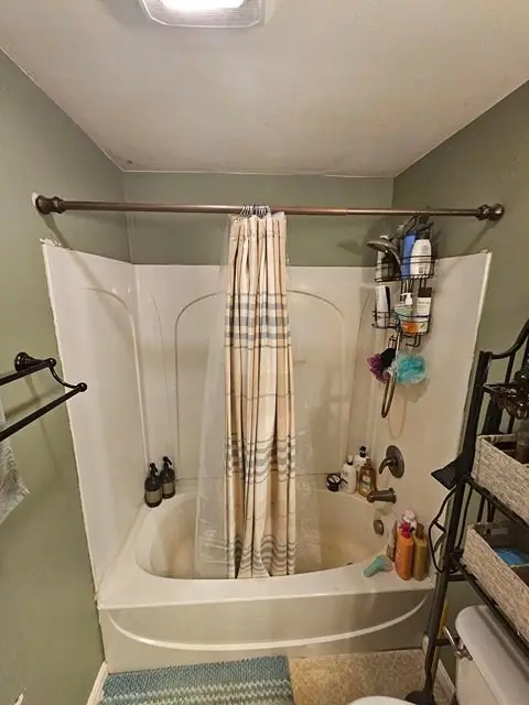 Before image of a bathroom with old tiles and fixtures needing renovation.